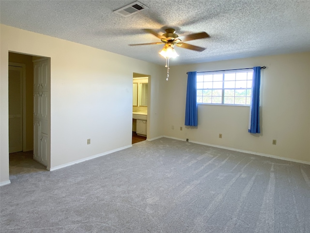 carpeted spare room with ceiling fan and a textured ceiling