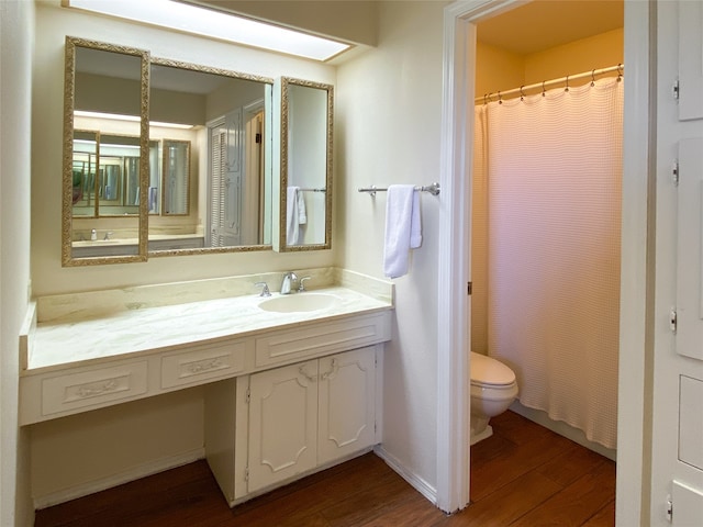 bathroom featuring vanity, hardwood / wood-style flooring, and toilet