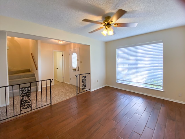 spare room featuring a textured ceiling, ceiling fan, and dark hardwood / wood-style flooring