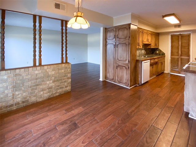 kitchen featuring tasteful backsplash, sink, dark hardwood / wood-style flooring, pendant lighting, and dishwasher