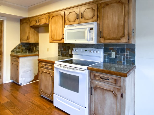 kitchen with dark wood-type flooring, white appliances, and backsplash