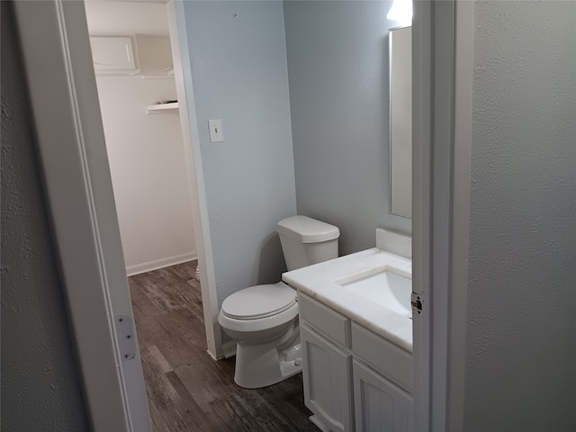 bathroom featuring vanity, hardwood / wood-style floors, and toilet