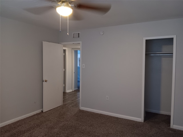 unfurnished bedroom featuring dark colored carpet, ceiling fan, and a closet