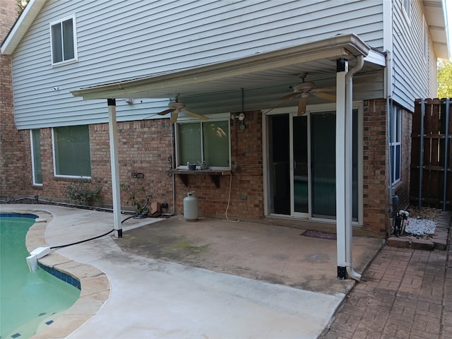 back of house with ceiling fan, a fenced in pool, and a patio