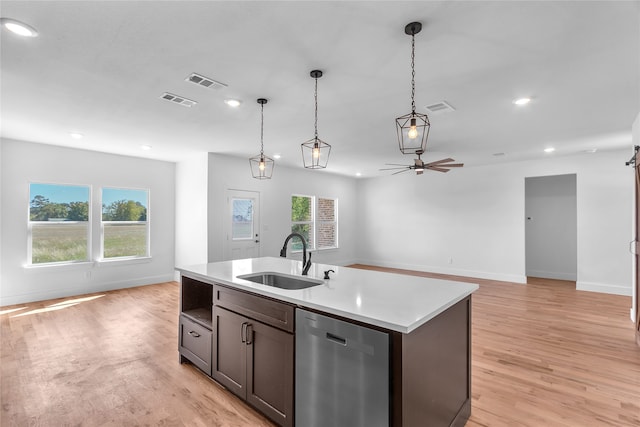 kitchen featuring light hardwood / wood-style floors, sink, stainless steel dishwasher, and an island with sink