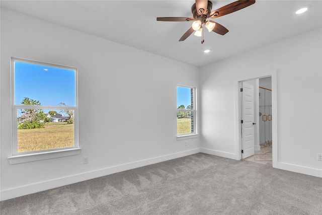 unfurnished bedroom featuring light colored carpet, a walk in closet, and ceiling fan