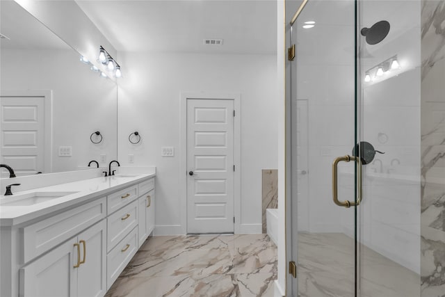 bathroom featuring a shower with door and vanity