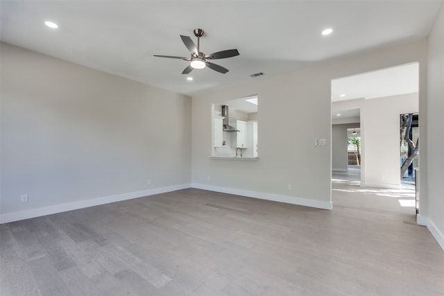 unfurnished living room featuring light wood-type flooring and ceiling fan