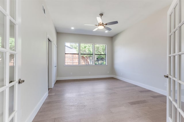 spare room with ceiling fan, light wood-type flooring, and french doors