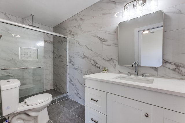 bathroom featuring tile walls, vanity, a shower with door, and toilet