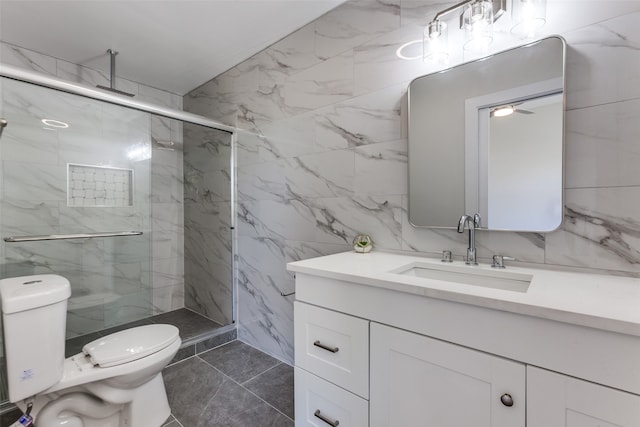 bathroom featuring a shower with shower door, toilet, tile walls, vanity, and tile patterned flooring