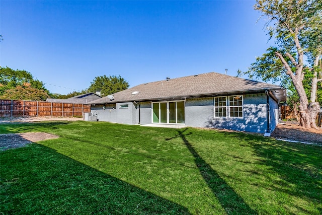 rear view of property featuring a lawn