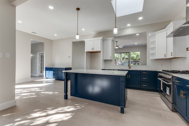 kitchen featuring a kitchen island, blue cabinets, high end range, decorative light fixtures, and white cabinets