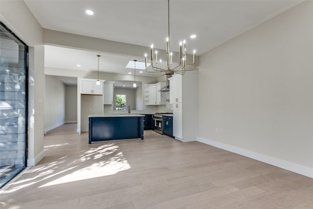 kitchen featuring white cabinets, stainless steel gas range oven, hanging light fixtures, light hardwood / wood-style floors, and blue cabinets