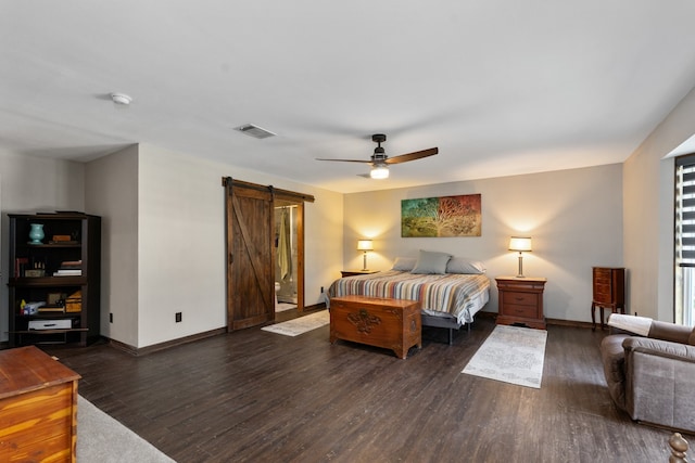 bedroom featuring dark wood-type flooring, a barn door, and ceiling fan