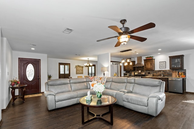 living room featuring ceiling fan with notable chandelier, sink, and dark hardwood / wood-style flooring