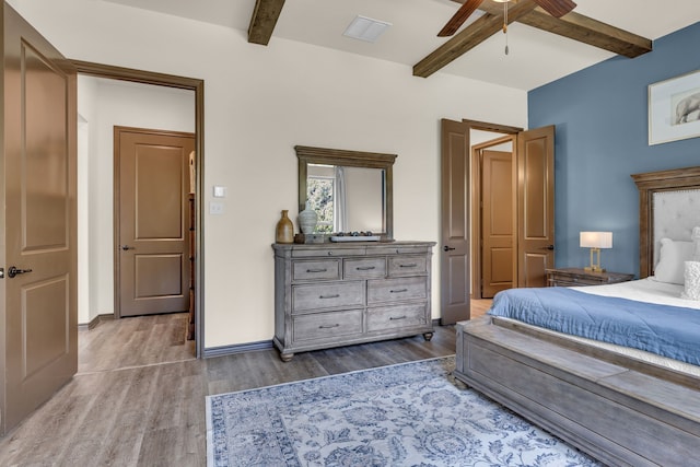 bedroom with beamed ceiling, ceiling fan, and hardwood / wood-style floors