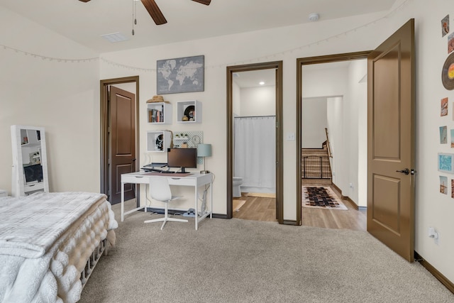 carpeted bedroom with ceiling fan, vaulted ceiling, and ensuite bathroom