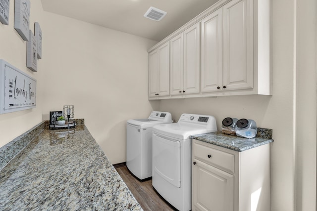 laundry area with cabinets, dark hardwood / wood-style flooring, and washer and dryer