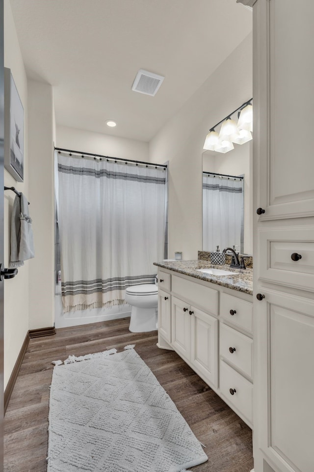 bathroom featuring vanity, hardwood / wood-style floors, and toilet