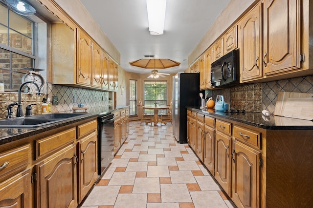 kitchen featuring ceiling fan, dark stone countertops, sink, decorative backsplash, and black appliances