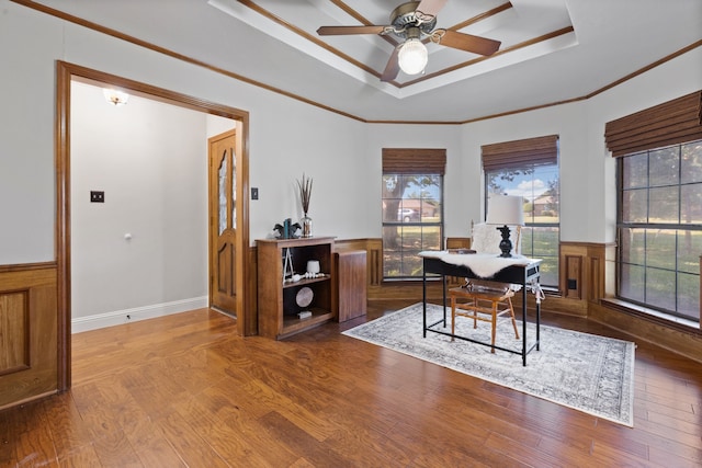 office with a raised ceiling, ornamental molding, hardwood / wood-style flooring, and ceiling fan