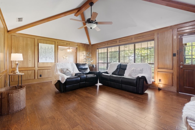 living room featuring beam ceiling, hardwood / wood-style flooring, wooden walls, and ceiling fan