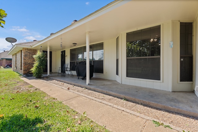 view of exterior entry featuring a patio area