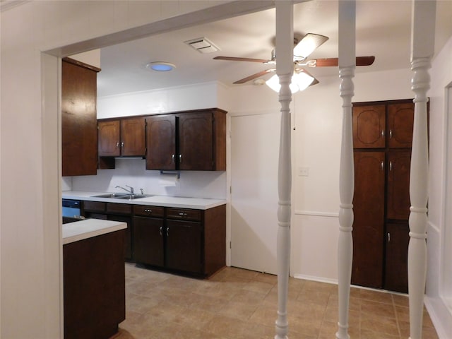 kitchen featuring dark brown cabinetry, decorative columns, sink, and ceiling fan