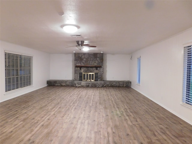 unfurnished living room featuring ceiling fan, a fireplace, and hardwood / wood-style floors