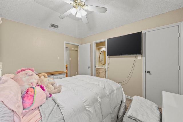 bedroom with ceiling fan, carpet floors, connected bathroom, and a textured ceiling