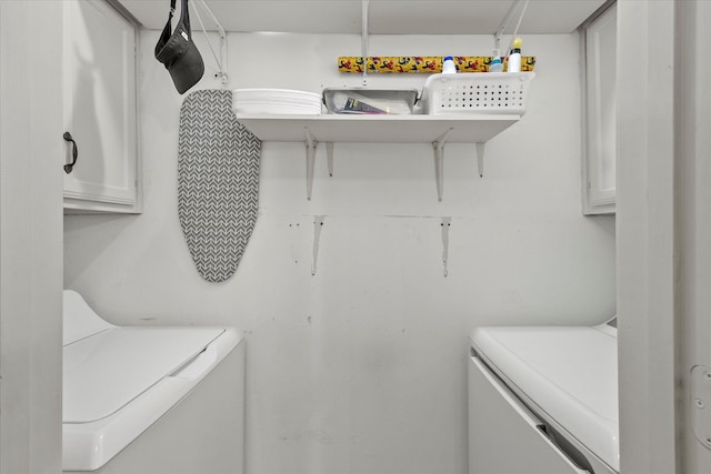 washroom with washing machine and clothes dryer and cabinets