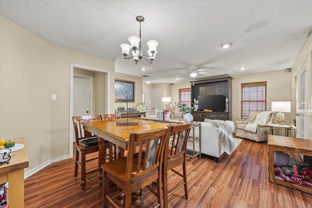 dining area with a textured ceiling, ceiling fan with notable chandelier, and hardwood / wood-style floors