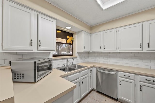 kitchen featuring white cabinetry, sink, appliances with stainless steel finishes, light tile patterned floors, and a textured ceiling