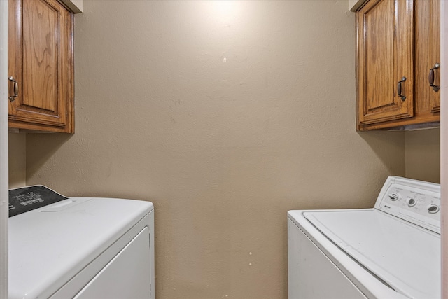 washroom with separate washer and dryer and cabinets