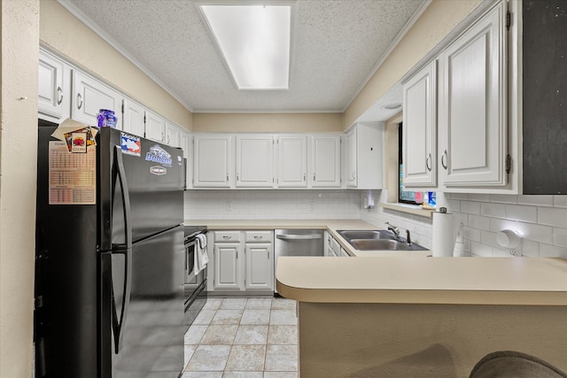 kitchen with black fridge, stove, white cabinets, sink, and kitchen peninsula