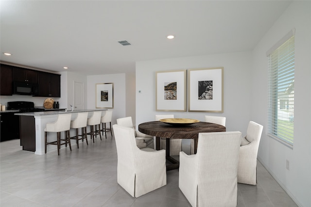 dining space featuring light tile patterned floors and sink