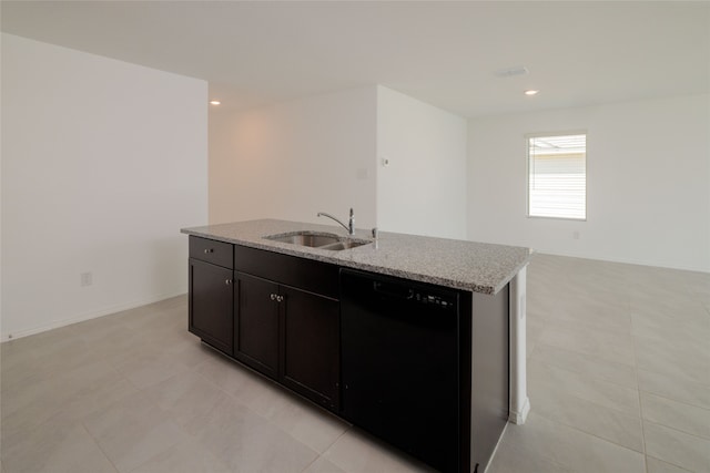 kitchen featuring light stone countertops, dishwasher, a kitchen island with sink, and sink