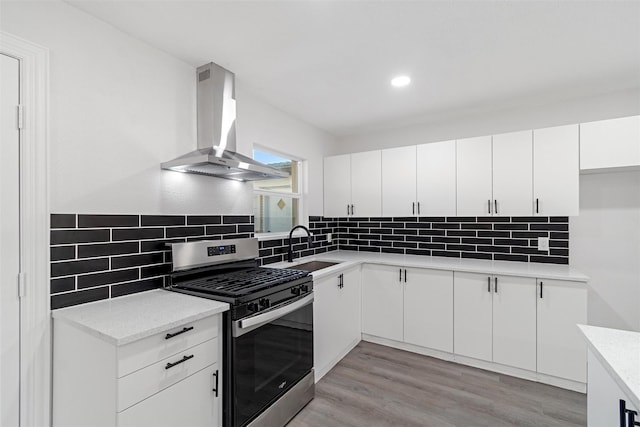 233 Oak Dr E, Hurst, TX 76053 - kitchen with gas range, ventilation hood, a sink, decorative backsplash, and recessed lighting