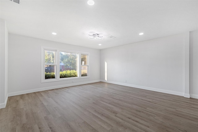 233 Oak Dr E, Hurst, TX 76053 - spare room with wood finished floors, recessed lighting, and baseboards