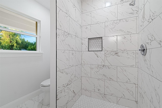 bathroom featuring toilet and a tile shower