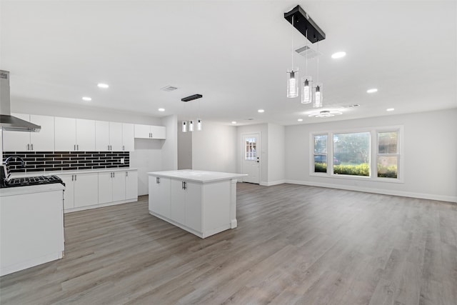 kitchen with pendant lighting, white cabinetry, a center island, and decorative backsplash