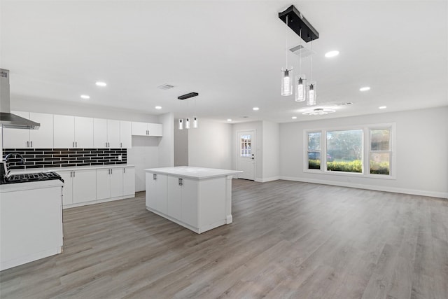 233 Oak Dr E, Hurst, TX 76053 - kitchen featuring light wood-style flooring, a kitchen island, recessed lighting, white cabinetry, and extractor fan