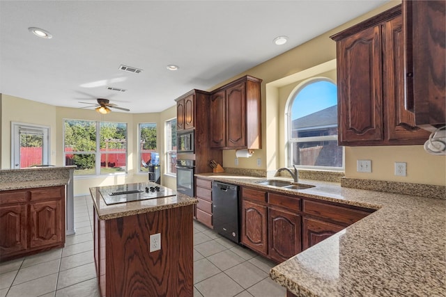 kitchen featuring a center island, sink, light tile patterned floors, and black appliances