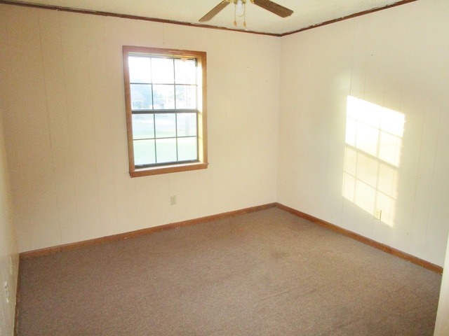 carpeted empty room featuring ceiling fan and crown molding