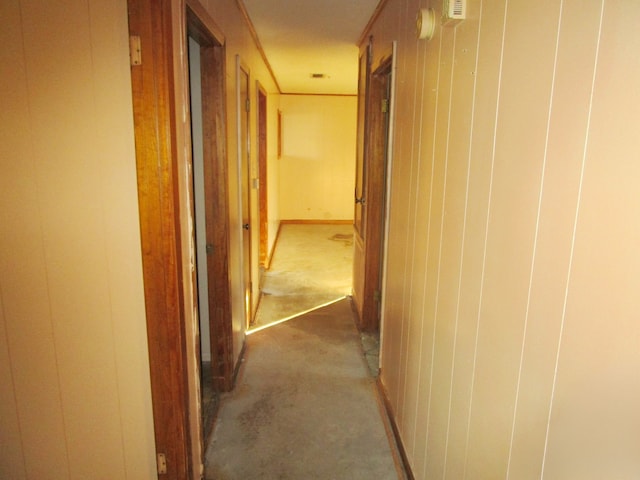 hall featuring wood walls and carpet flooring