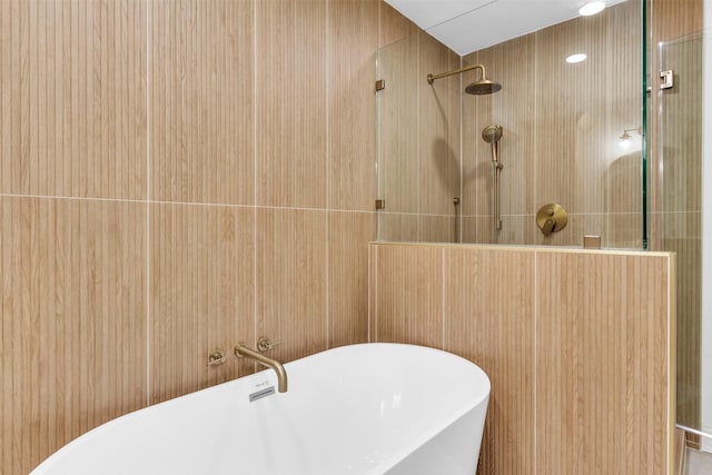 full bathroom featuring a freestanding bath and tiled shower