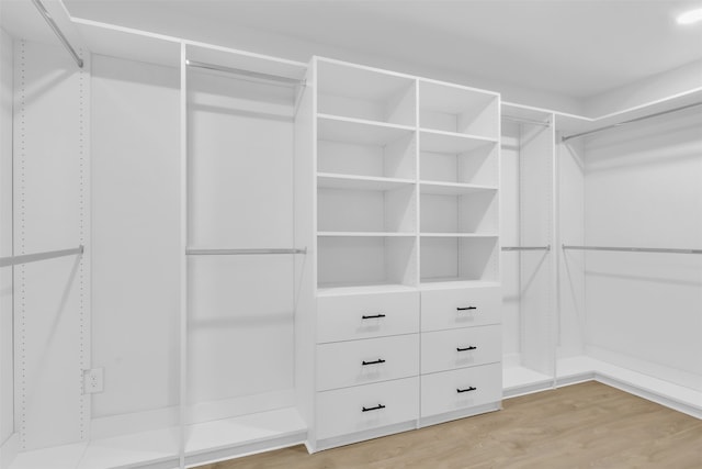 walk in closet with light hardwood / wood-style floors