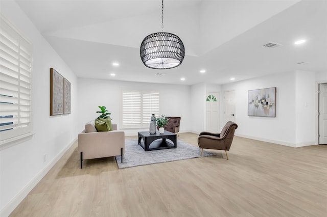 living room featuring vaulted ceiling and light hardwood / wood-style floors