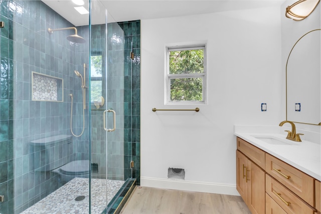 bathroom featuring an enclosed shower, vanity, and hardwood / wood-style flooring